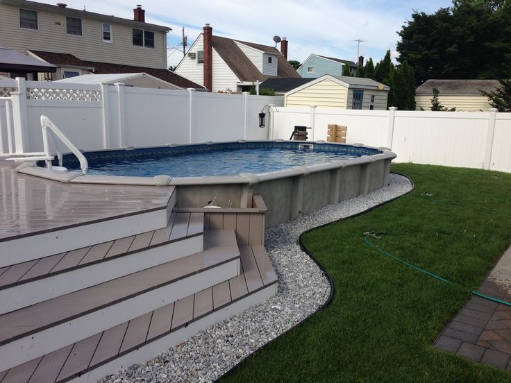 an above ground swimming pool with steps leading up to the deck and back yard area