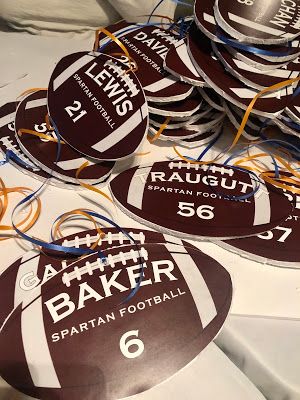 there are many brown and white footballs on the table with strings attached to them