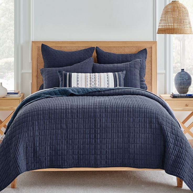 a bed with blue comforters and pillows in a room