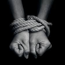 two hands tied up with rope in the dark, black and white photo by mark taylor