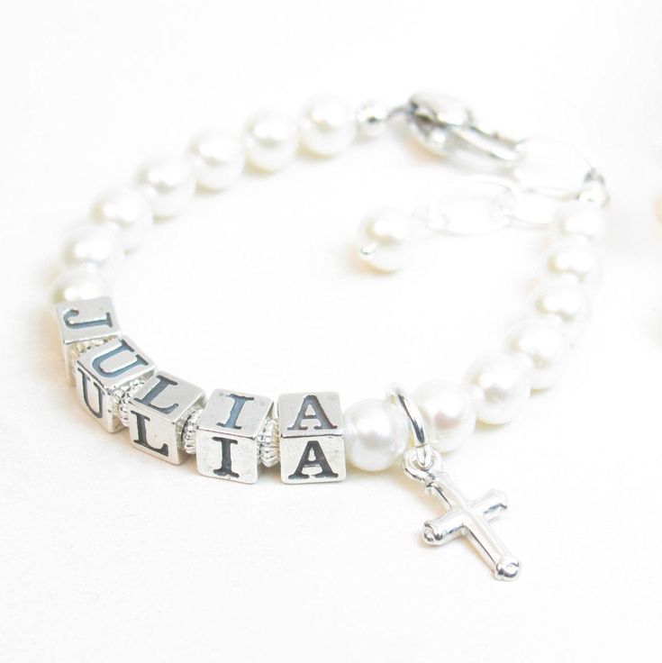 "Real Pearl Name Bracelet for Infant, Baby, or Girl. Created with 5.5mm genuine freshwater pearls, sterling silver block alphabet beads, a heart-shaped lobster clasp with a 1/2\" \"Grow-with-Me\" extender chain, and one sterling silver charm of your choice. Corrugated saucers separate the letters - giving the bracelet textural and visual interest. All metal components are sterling silver. Arrives packaged in my signature high-quality reusable canvas gift bag. Beautiful and ready for gift giving. Pearl Name, Real Pearl Bracelet, White Pearl Jewelry, Baby Necklace, Baby Pearls, Initial Earrings, First Communion Gifts, Alphabet Beads, Baby Bracelet