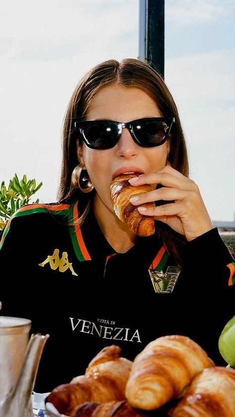 a woman eating croissants while sitting at a table