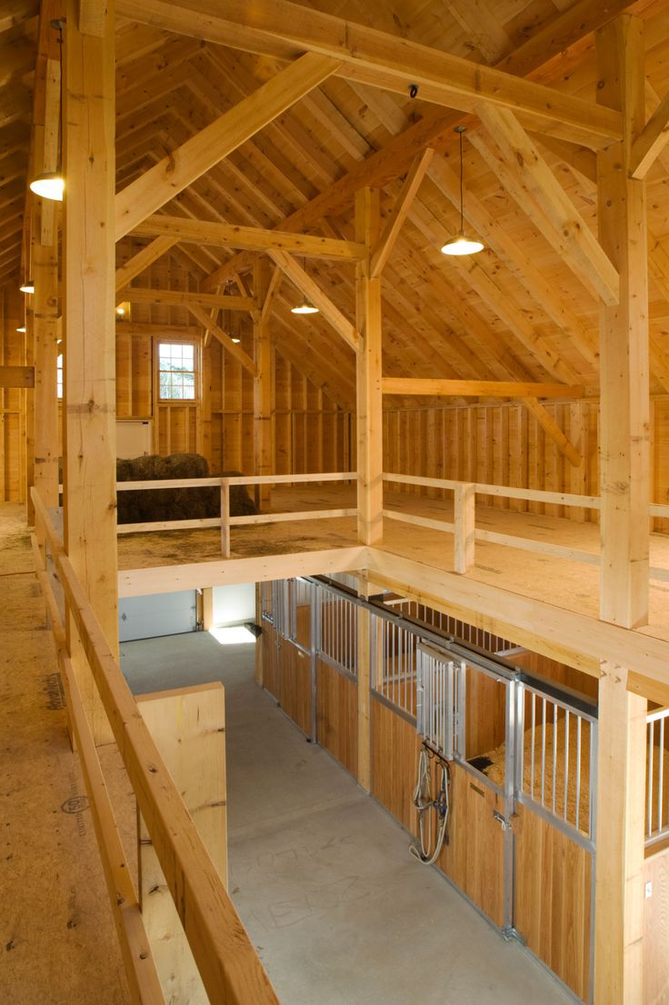 the inside of a horse barn with lots of wood