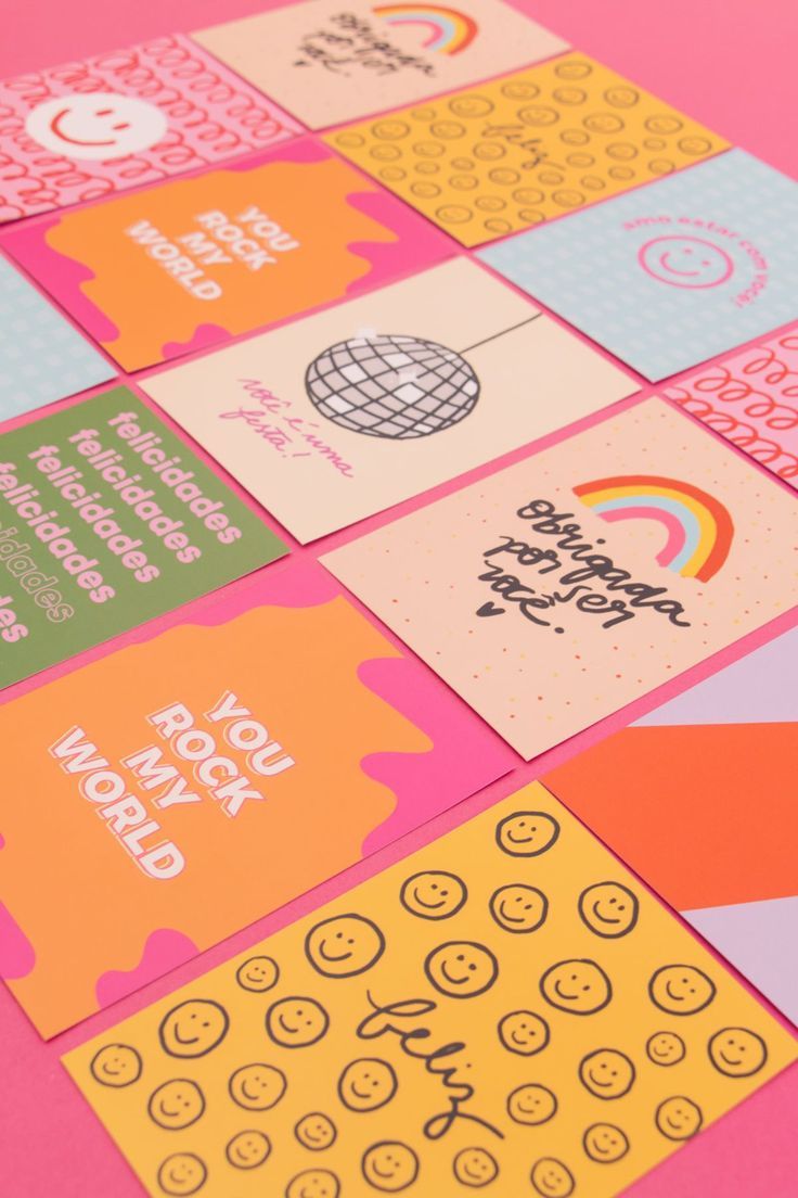 several different colored cards on a pink surface with the words happy new year written across them