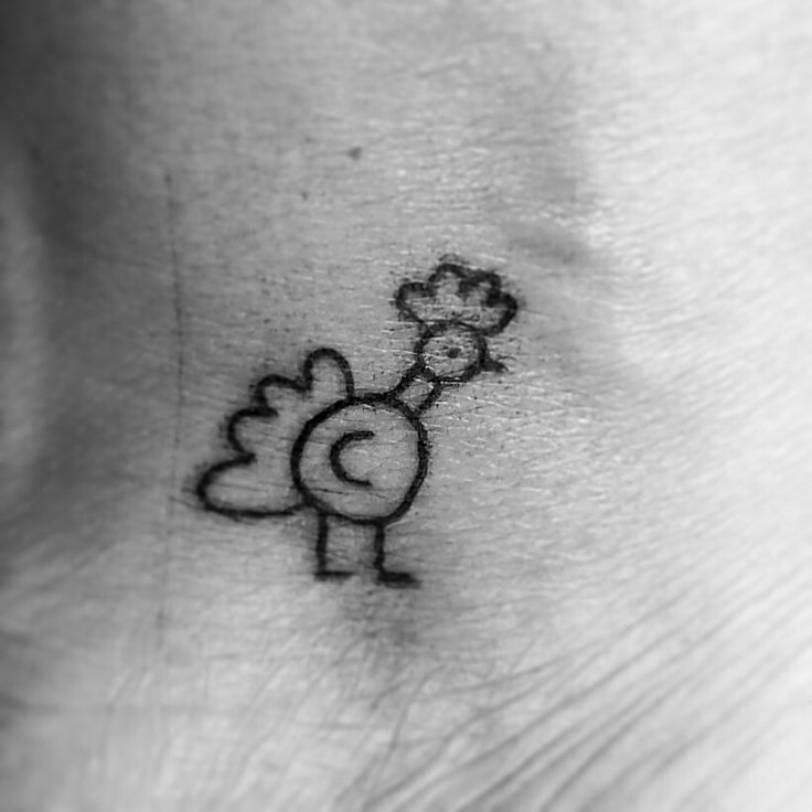 a black and white photo of a small tattoo