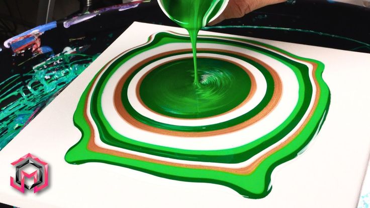 a person is pouring green liquid into a white square with an orange and brown design