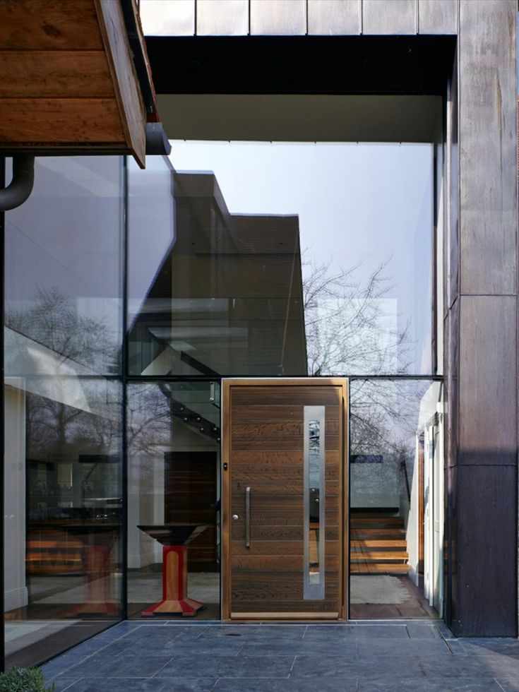 A solid front door in a wall of glass Glass Entrance Doors, Oak Cladding, Contemporary Front Doors, Make A Door, Security Doors, Glazed Walls, Stone Cladding, Pivot Doors, Front Door Design