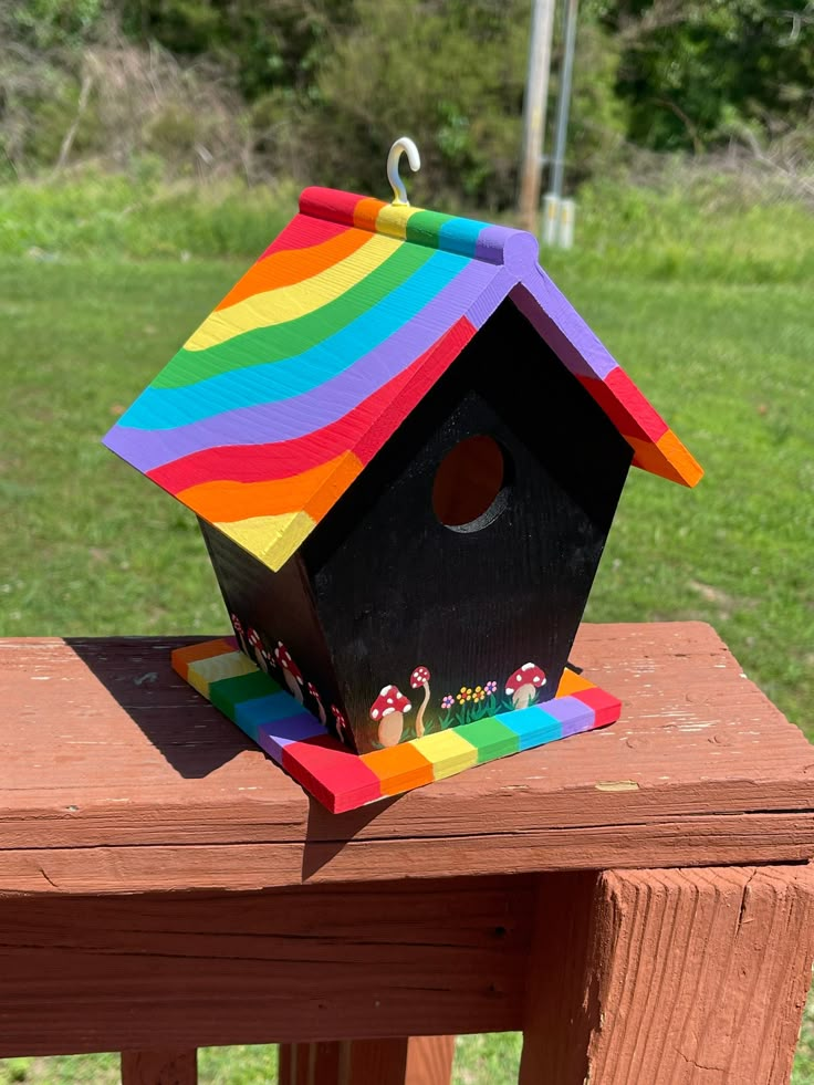 a colorful birdhouse sitting on top of a wooden table