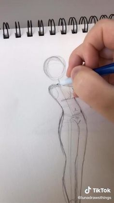 someone is drawing a woman's dress on paper