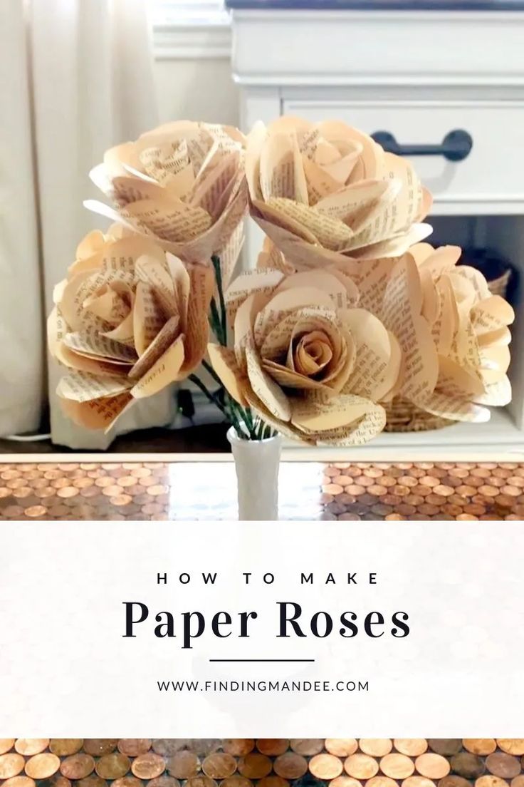 paper roses in a vase on top of a table next to stacks of pennets