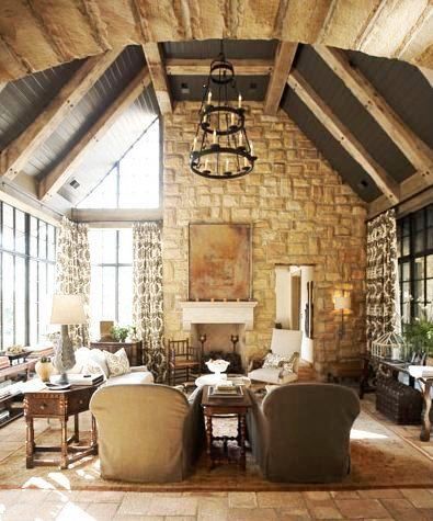 a living room filled with lots of furniture next to tall windows and a chandelier hanging from the ceiling