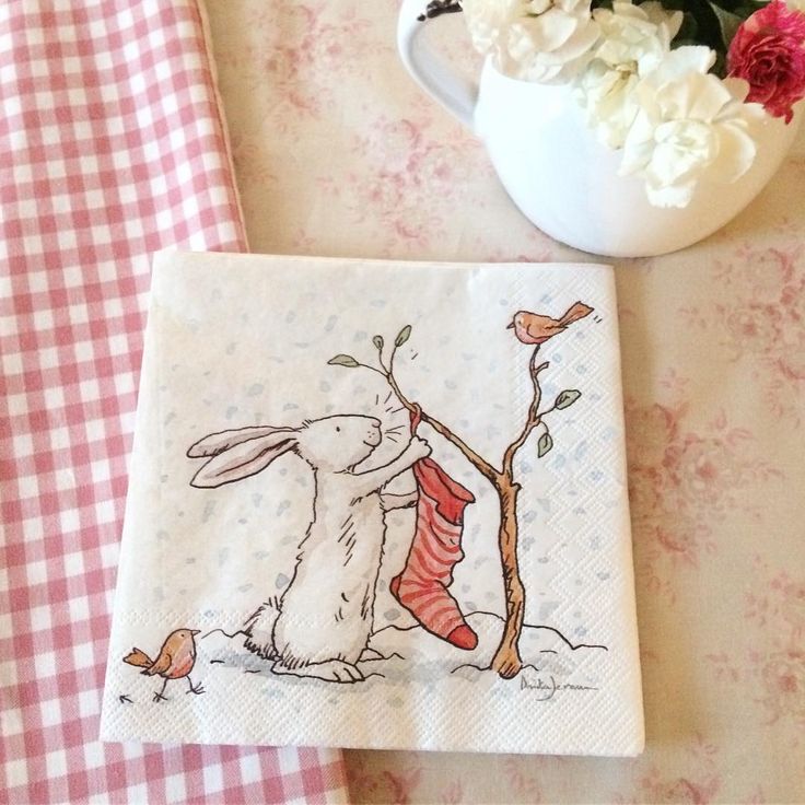 a napkin with a bunny and bird on it next to a potted plant in a vase