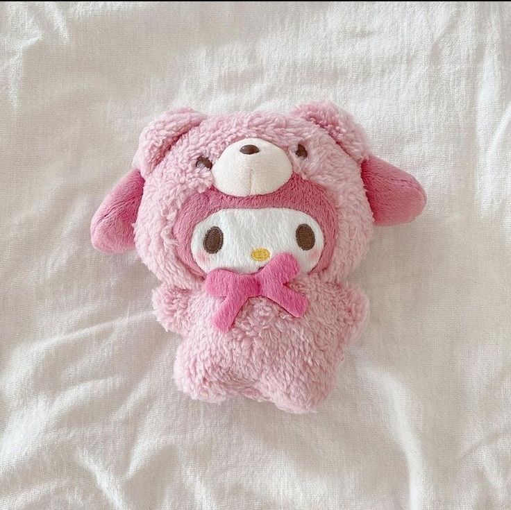 a pink stuffed animal laying on top of a bed