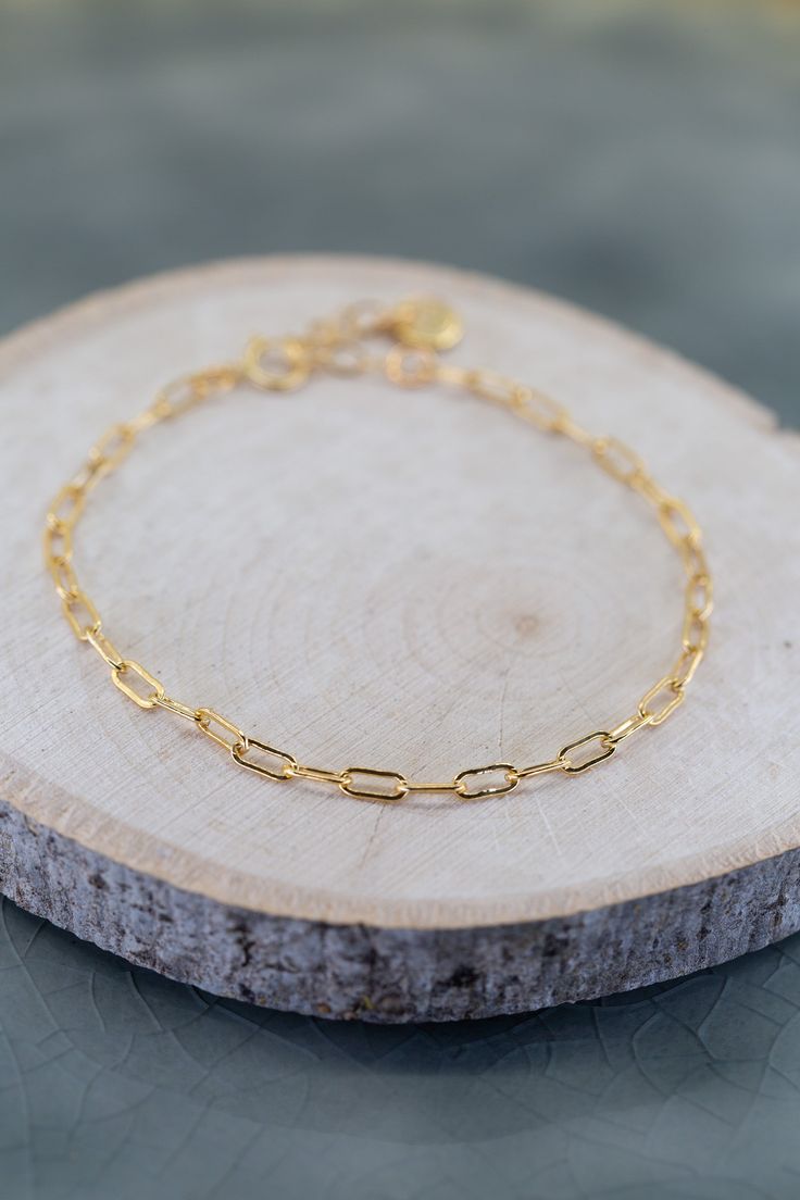 Introducing the Elements Cable Chain Gold Bracelet. This stunning bracelet is crafted from 14K gold plated brass, exuding timeless elegance. With its adjustable clasp, it offers the perfect fit for any wrist. Elevate your style with this exquisite piece that effortlessly combines sophistication and versatility. Chain Link Bracelet With Gold Clasp Gift, Adjustable Yellow Gold Plated Paperclip Bracelet, Gold Plated Bracelet With Gold Clasp As Gift, Adjustable Gold Charm Bracelet For Formal Occasions, Gold Bangle Chain Bracelet In 14k Gold Filled, Gift Gold Plated Bracelet With Gold Clasp, Gold Link Chain Bracelet With Lobster Clasp, Adjustable Gold Charm Bracelet With Delicate Chain, Gold-plated Link Bracelet With Gold Clasp