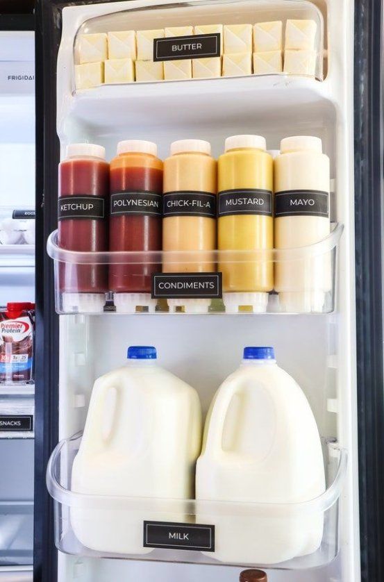 an open refrigerator filled with lots of different types of milks and condiments