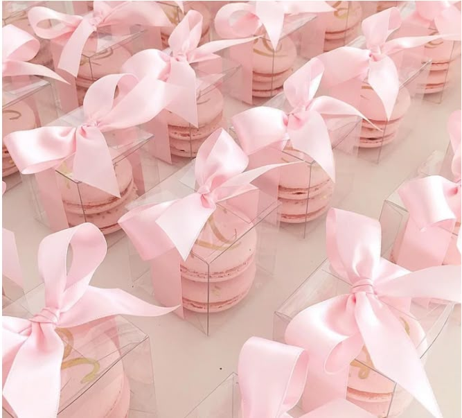 many small pink boxes with bows on them