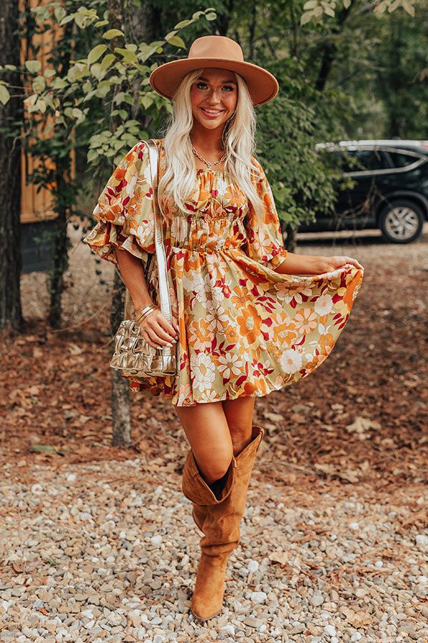 - This gorgeous dress brings all the colors of fall together for a stylish look! - Fully lined material with an orange, pink, red, and yellow hued floral print and a satin finish - An elastic scoop neckline - A bodice with pleated detail and side zip closure - An elastic waistline with a tie detail for additional waist cinching - Puffy half sleeves with elastic ruffle cuffs - A flowy yet flattering silhouette that ends in a mini dress length hemline Measurements S : Bust 32", Hip 38", Length 27" Fall Floral Dress For Brunch, Fall Bohemian Mini Dress For Garden Party, Fall Floral Mini Dress For Garden Party, Bohemian Mini Dress For Garden Party In Fall, Mini Floral Dress For Fall Garden Party, Orange Dress For Day Out In Fall, Fall Bohemian Pleated Dress, Flowy Floral Dress For Fall, Bohemian Pleated Fall Dresses