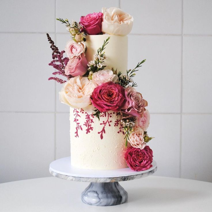 a white cake with pink and red flowers on top