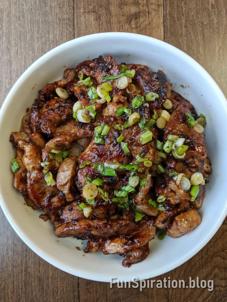 a white bowl filled with meat and vegetables