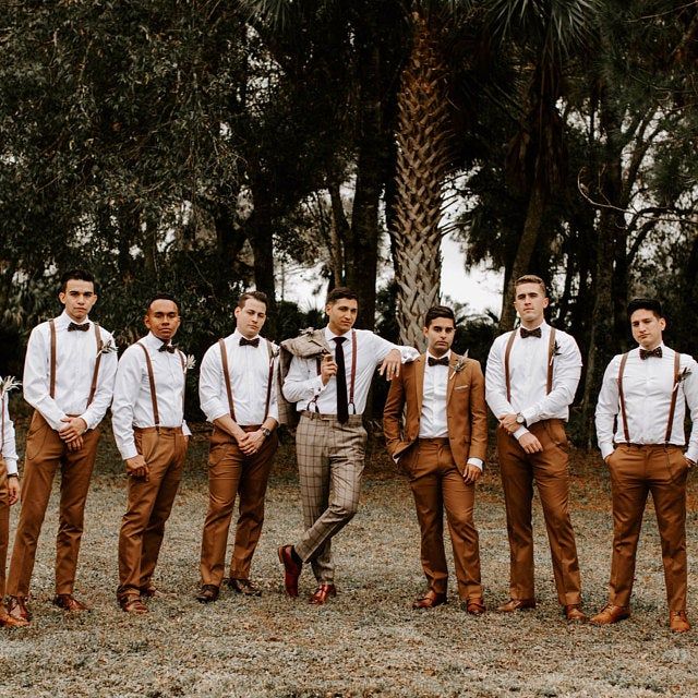 a group of young men standing next to each other in front of some tall trees