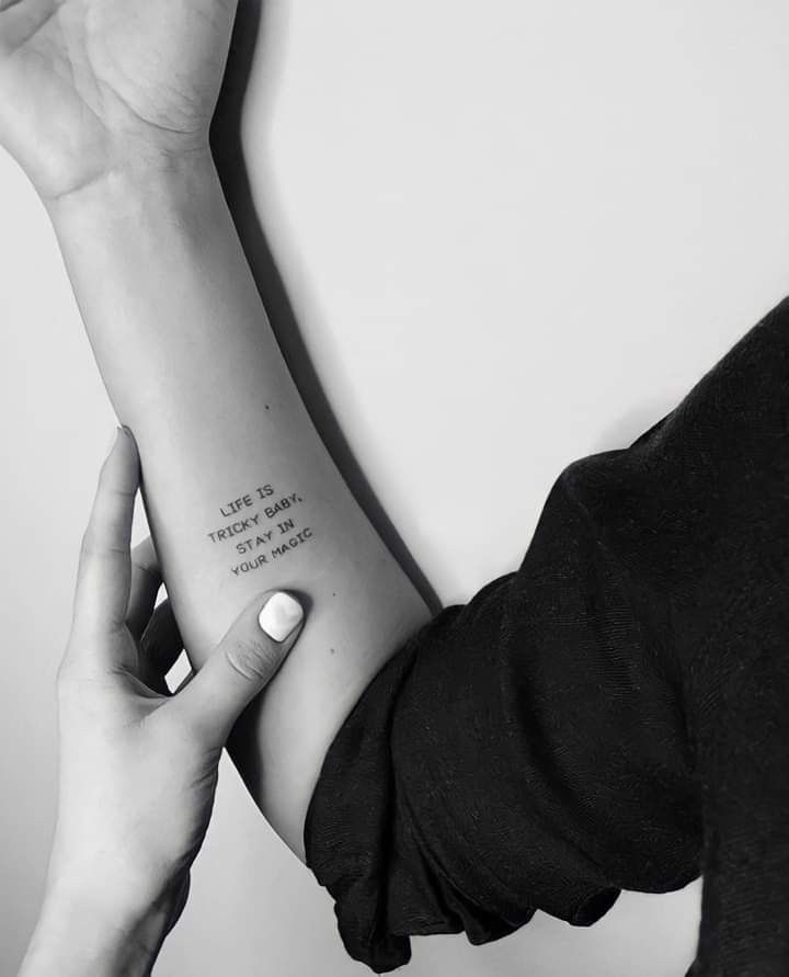 a woman's arm with a quote tattooed on the left side of her arm