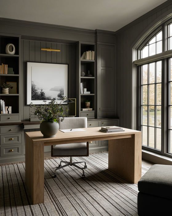 an office with gray walls and wooden furniture