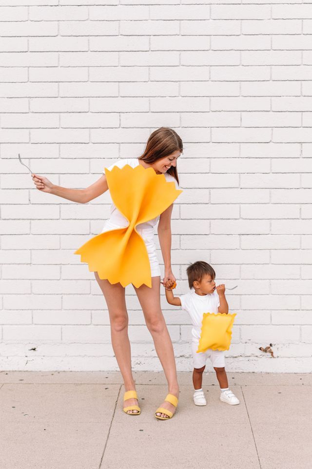 a woman holding the hand of a small child dressed as pikachu