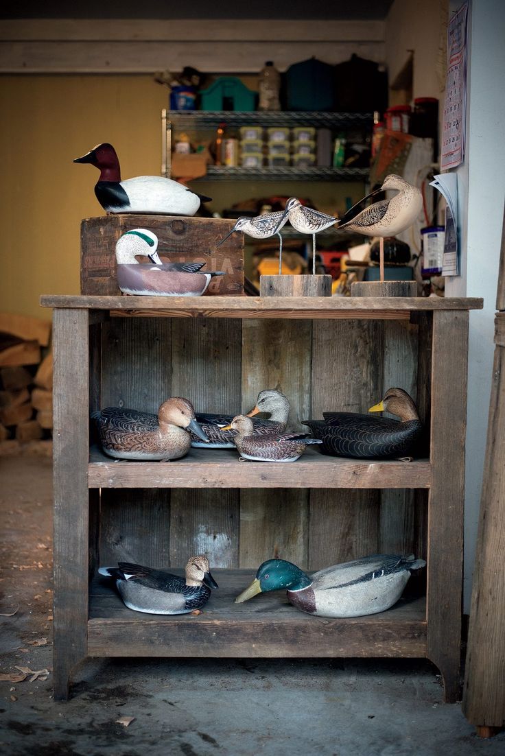 an old wooden shelf filled with different types of bird figurines on top of it