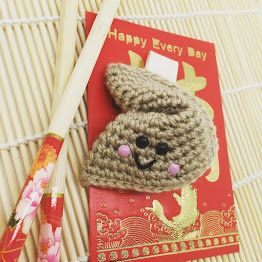 two chopsticks laying on top of a card with a crocheted bear