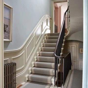 a staircase leading up to the first floor in a house with blue walls and white trim