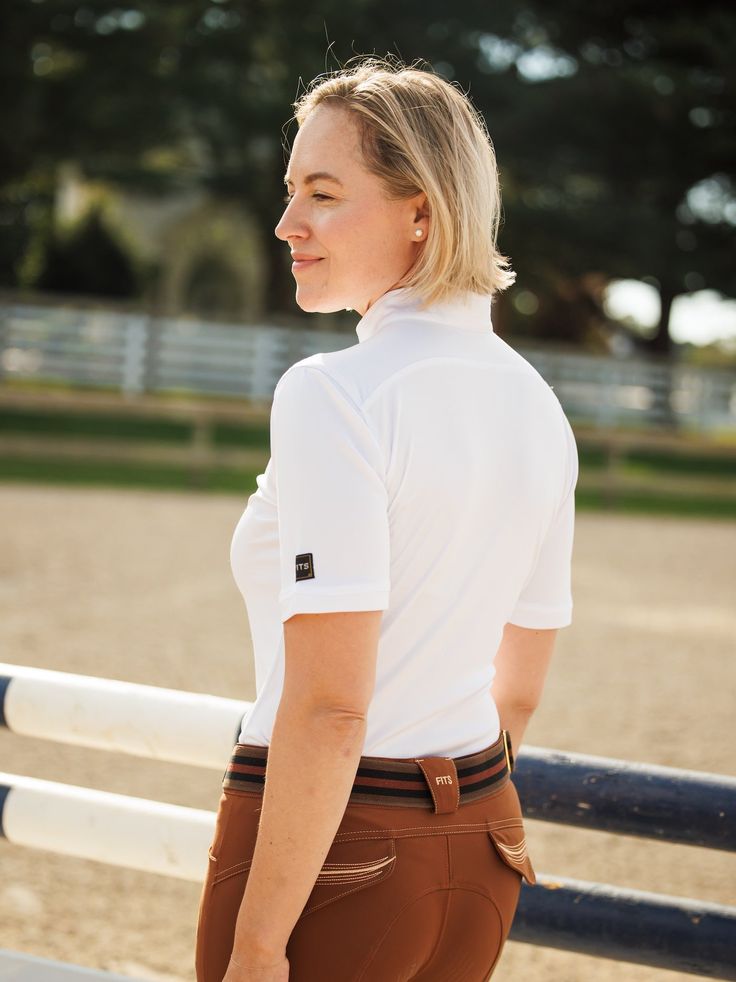 The all new Vital Short Sleeve Sun Shirt combines style, comfort, and flattering lines. This UPF 50 sun shirt features lightweight fabric that is wicking, fast drying, breathable, and pill-resistant. This polished shirt is available in black and white to outfit with any breeches! UPF 50 sun protection 1/4 zip neckline Moisture wicking and fast drying Antimicrobial protection and pill-resistant White Athleisure T-shirt For Outdoor, Breathable White Sports Shirt, White Breathable Sports Shirt, White Summer Sports Shirt, Fitted Sports Tops With Upf 50+, White Breathable 4-way Stretch Tops, Breathable 4-way Stretch White Tops, White Sporty Shirt With Moisture-wicking, White Sporty Moisture-wicking Shirt