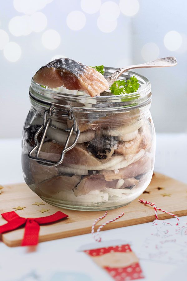 a glass jar filled with food sitting on top of a wooden cutting board next to a red ribbon