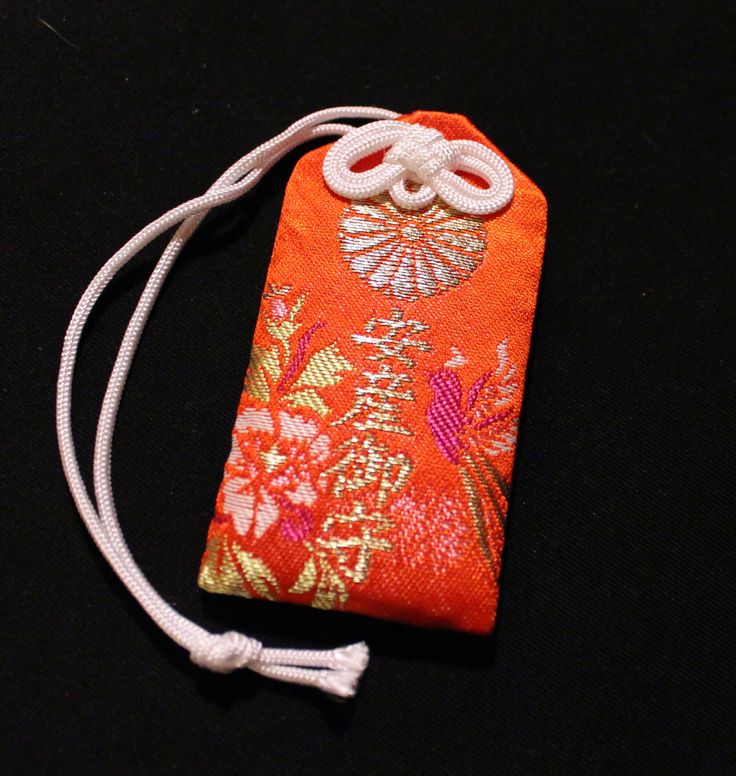 an orange case with white string attached to it on a black surface, containing two buttons