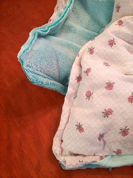 two baby blankets laying on the floor next to each other