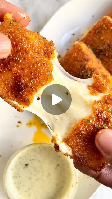 someone is dipping sauce on some food in a white bowl and holding it up to the camera