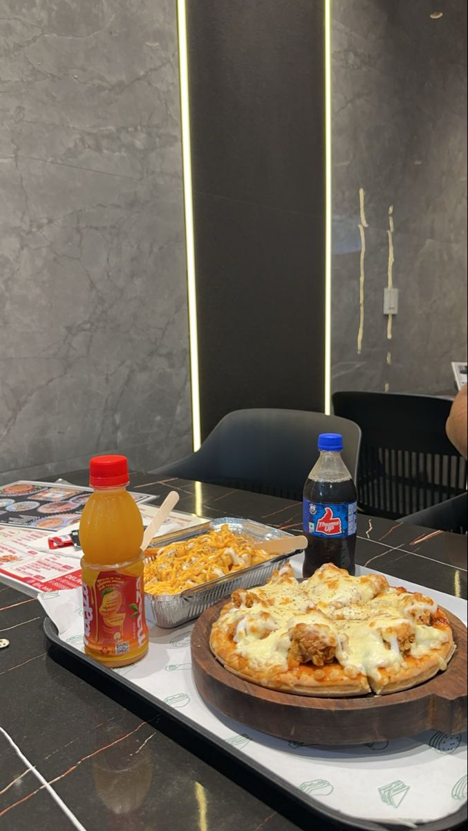 two pizzas sitting on top of a table with condiments