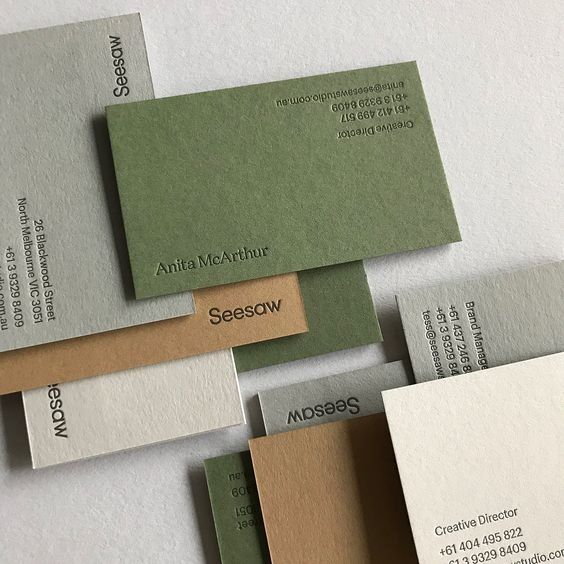 some business cards are stacked on top of each other with different colors and shapes in them