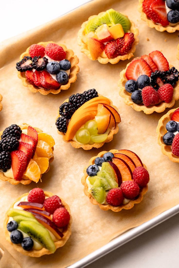 a tray filled with fruit tarts on top of a table