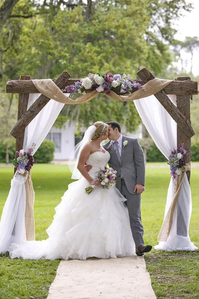 a bride and groom standing under an arch with flowers on it at their wedding ceremony