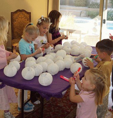 a group of children standing around a purple table