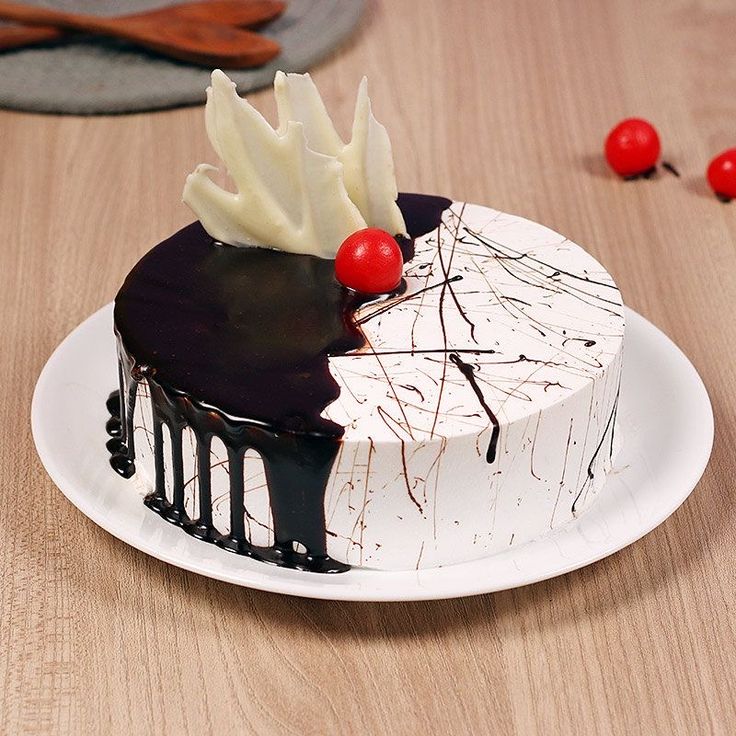 a white and black cake sitting on top of a wooden table next to a knife