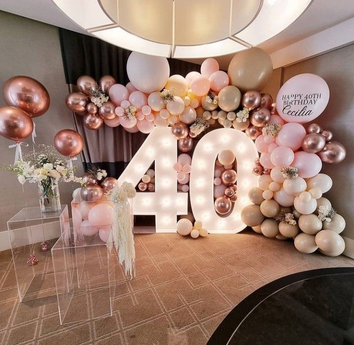 a large balloon arch with the number forty written in white and gold balloons on it