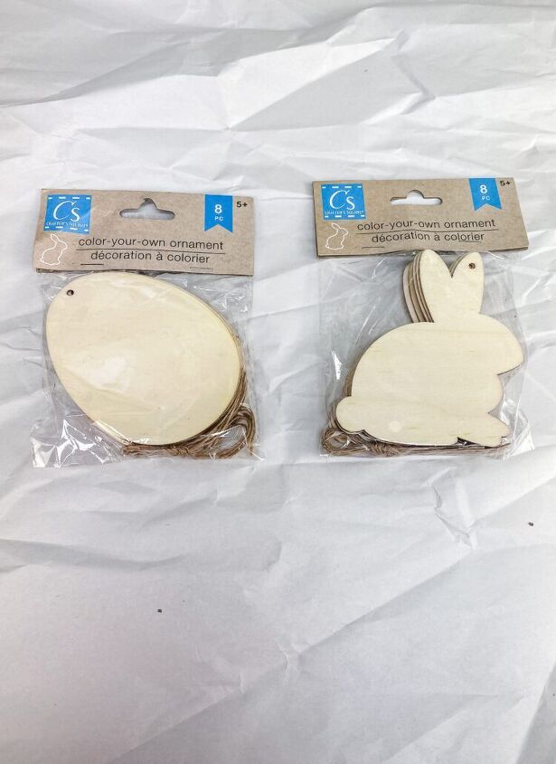 two wooden bunny coasters sitting on top of a plastic bag