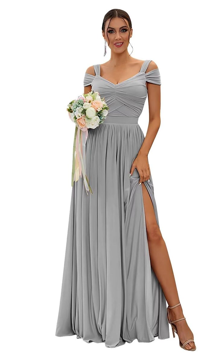 a woman wearing a grey dress with thigh high slits and a flower in her hand