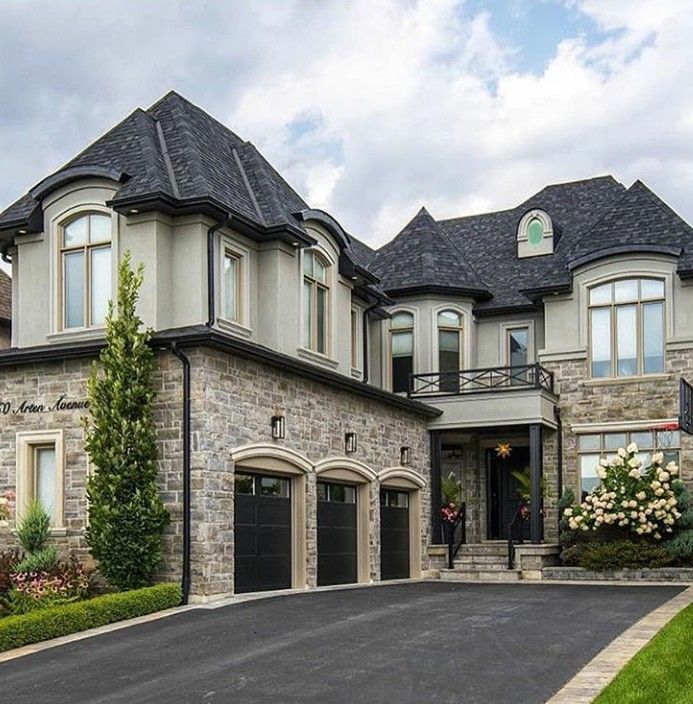 a large house with two car garages on the driveway