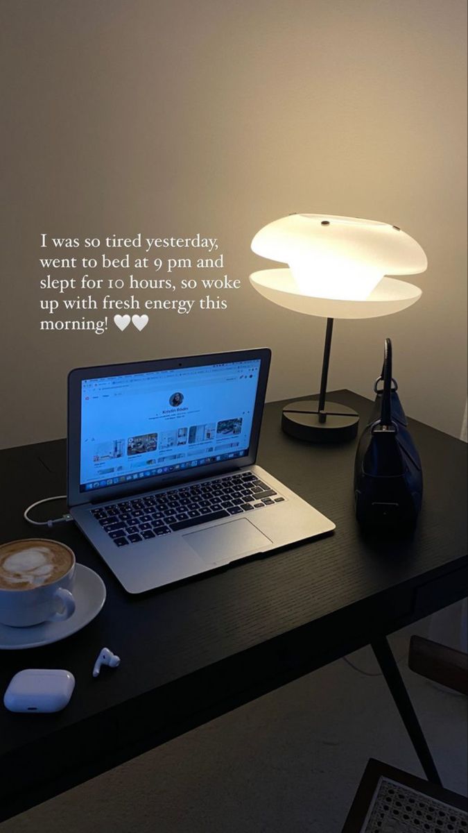 an open laptop computer sitting on top of a desk next to a cup of coffee