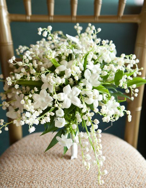 a bouquet of white flowers sitting on top of a chair