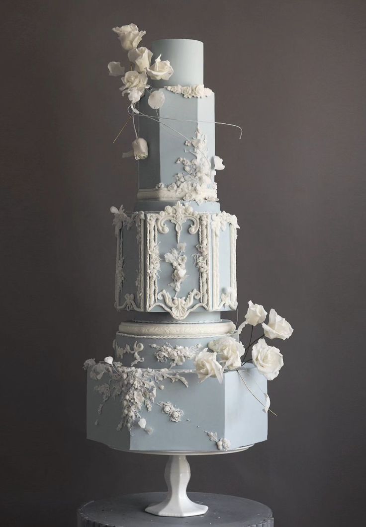 a three - tiered cake with white flowers on the top and sides is shown