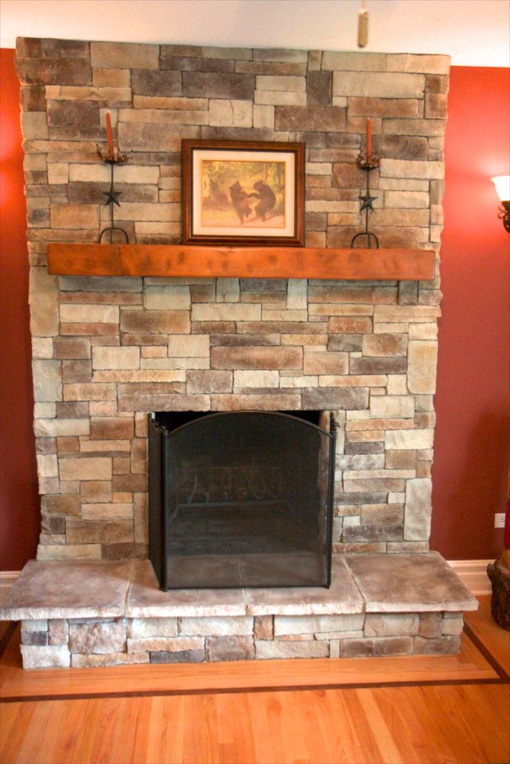 a living room with a stone fireplace and red walls