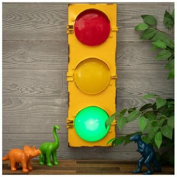 a traffic light sitting next to two toy dinosaurs